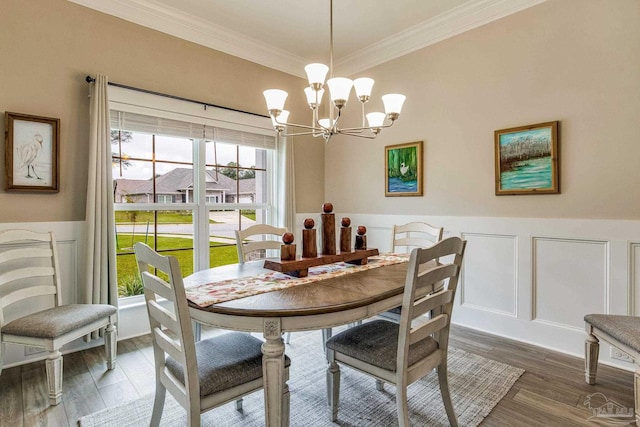 dining area featuring dark hardwood / wood-style flooring, an inviting chandelier, and ornamental molding