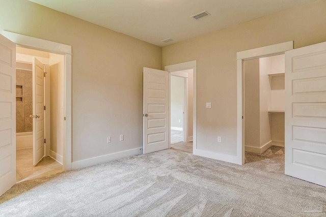 unfurnished bedroom with a closet and light carpet