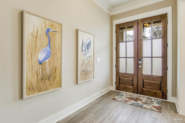 foyer entrance with hardwood / wood-style flooring, crown molding, and french doors