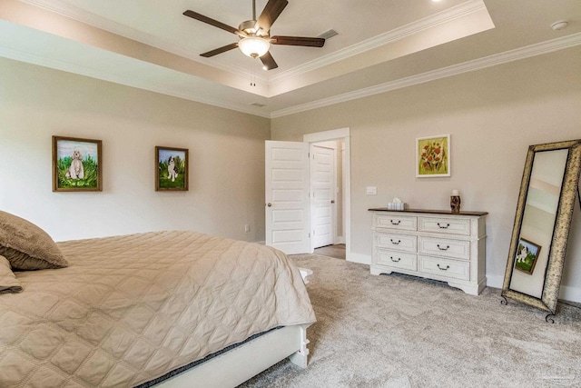 carpeted bedroom featuring ornamental molding, ceiling fan, and a tray ceiling