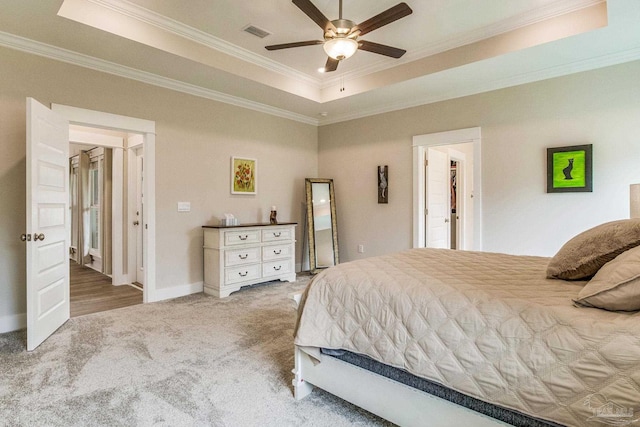 carpeted bedroom featuring a raised ceiling, ceiling fan, and crown molding