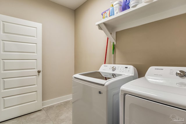 laundry room featuring washing machine and clothes dryer and light tile patterned floors