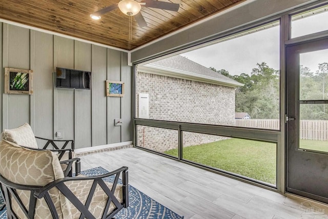 sunroom featuring wooden ceiling and ceiling fan