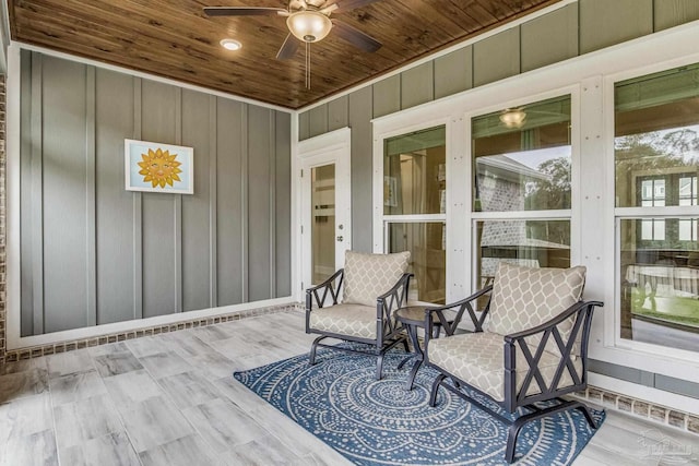 sunroom featuring ceiling fan and wood ceiling