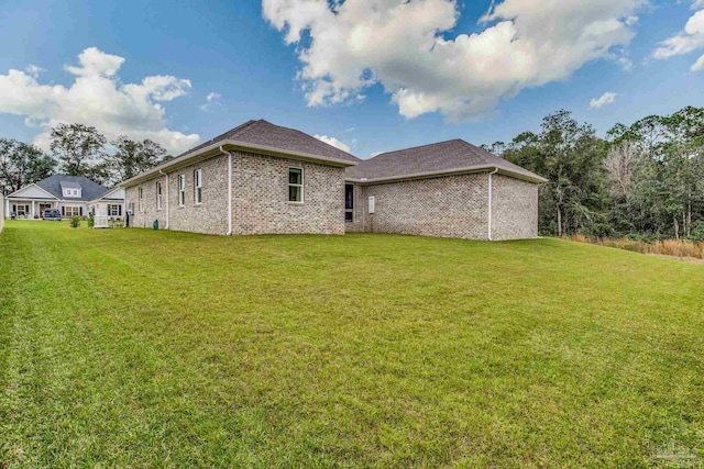 rear view of property featuring a lawn