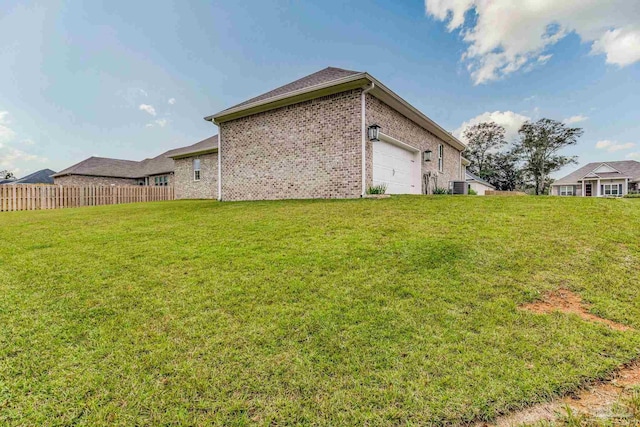 exterior space with a lawn, a garage, and cooling unit