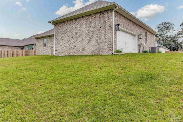 view of side of home with a garage, central AC unit, and a yard