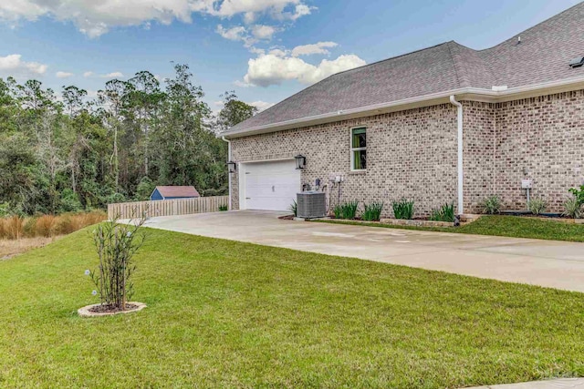 view of property exterior with a garage, a lawn, and central AC