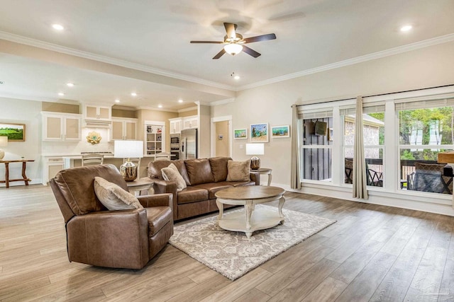 living room featuring ceiling fan, light wood-type flooring, and crown molding