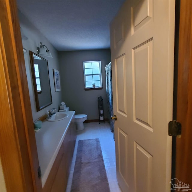 full bath with vanity, curtained shower, toilet, and baseboards