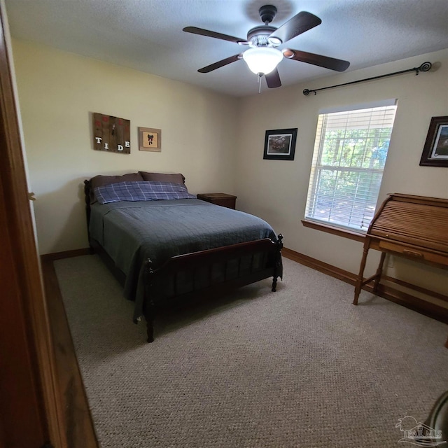 bedroom with a textured ceiling, a ceiling fan, carpet, and baseboards
