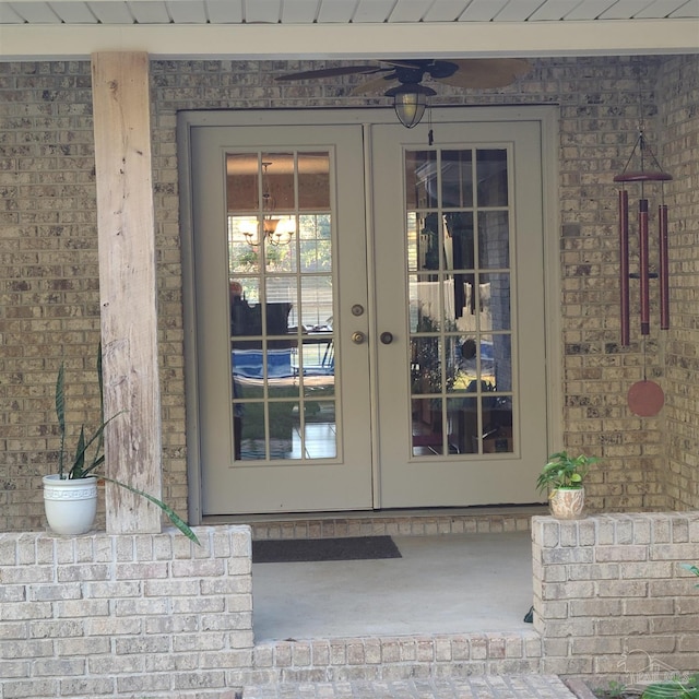 doorway to property with french doors, brick siding, and ceiling fan