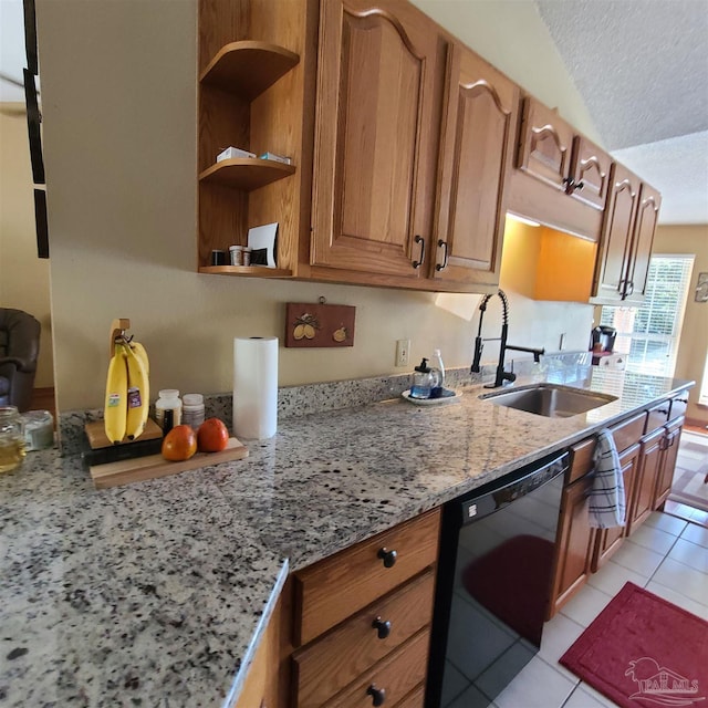 kitchen with brown cabinetry, light stone countertops, a sink, black dishwasher, and a textured ceiling
