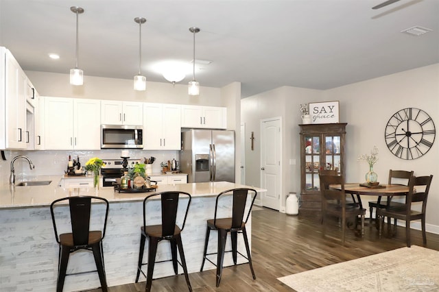9668 Nature Creek Blvd, Pensacola, FL 32526 - kitchen with stainless steel appliances, tasteful backsplash, a peninsula, dark wood-style floors, and a breakfast bar