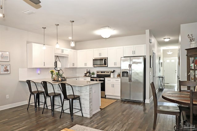 9668 Nature Creek Blvd, Pensacola, FL 32526 - kitchen featuring appliances with stainless steel finishes, a peninsula, a breakfast bar area, and dark wood-type flooring