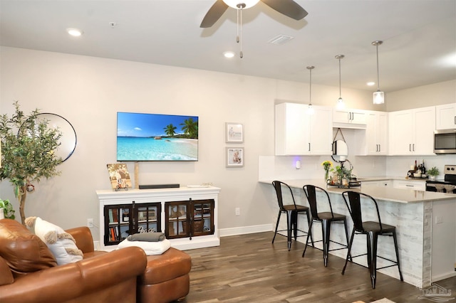 9668 Nature Creek Blvd, Pensacola, FL 32526 - kitchen with appliances with stainless steel finishes, a kitchen breakfast bar, ceiling fan, dark wood-style flooring, and a peninsula