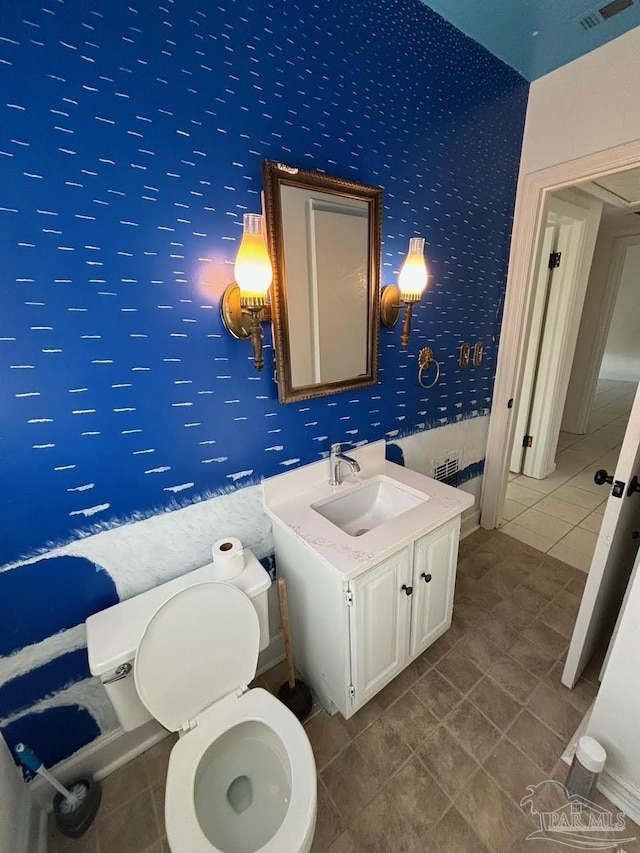 bathroom featuring vanity, tile patterned floors, and toilet