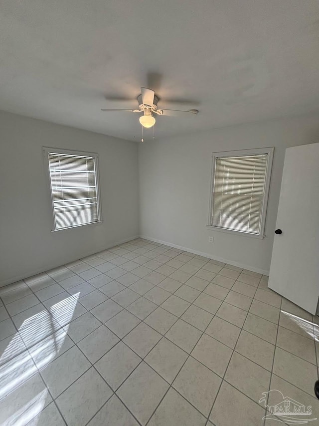 tiled spare room featuring ceiling fan