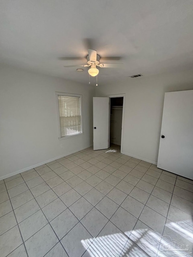 tiled spare room featuring ceiling fan