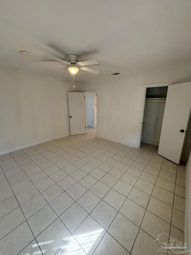 tiled spare room with ceiling fan