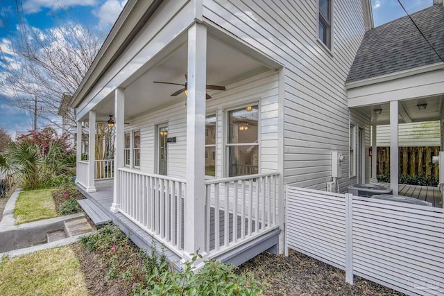 view of side of home featuring covered porch, a ceiling fan, and a shingled roof