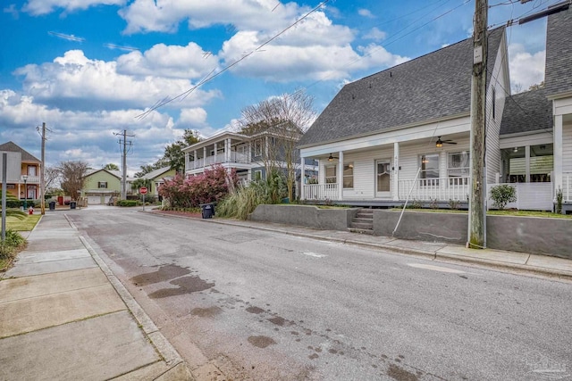 view of street with curbs, traffic signs, sidewalks, and a residential view