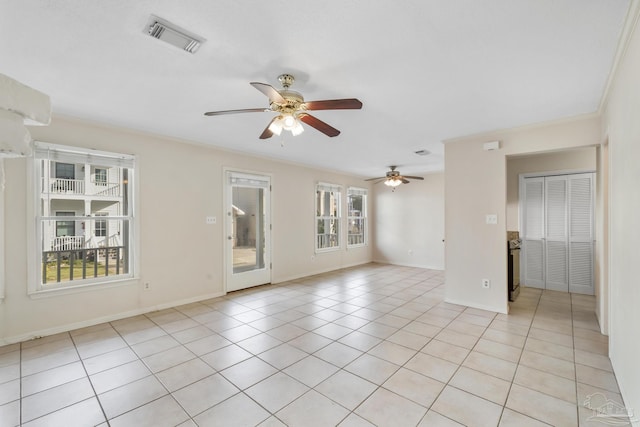 unfurnished room featuring light tile patterned floors, baseboards, visible vents, a ceiling fan, and ornamental molding