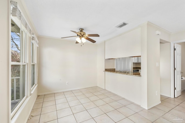 unfurnished room featuring visible vents, baseboards, ceiling fan, ornamental molding, and light tile patterned flooring