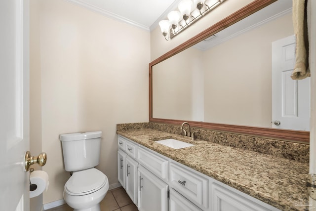 bathroom featuring tile patterned flooring, toilet, vanity, baseboards, and crown molding