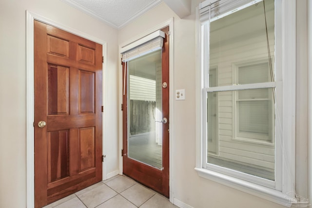 foyer featuring ornamental molding, light tile patterned flooring, and a textured ceiling