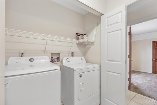 washroom featuring washing machine and dryer, laundry area, light colored carpet, and light tile patterned flooring