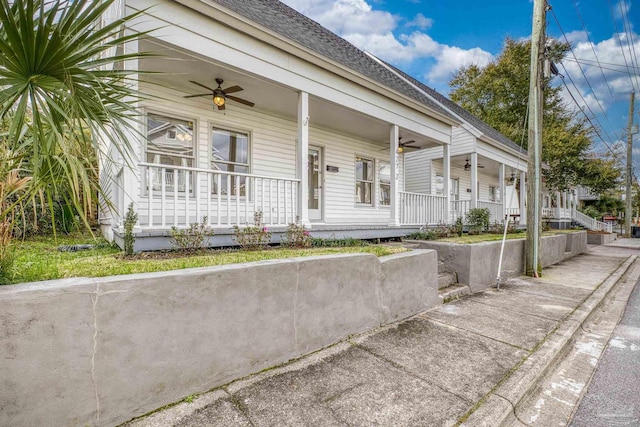 view of front of property featuring covered porch, a shingled roof, and a ceiling fan