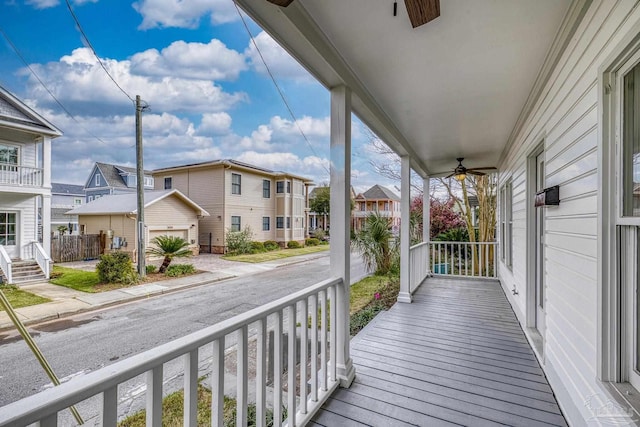 wooden deck with a porch, a residential view, and ceiling fan