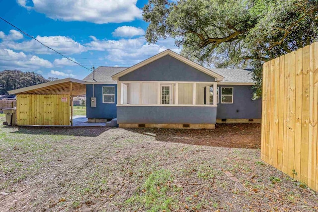 back of house with roof with shingles, crawl space, fence, and stucco siding