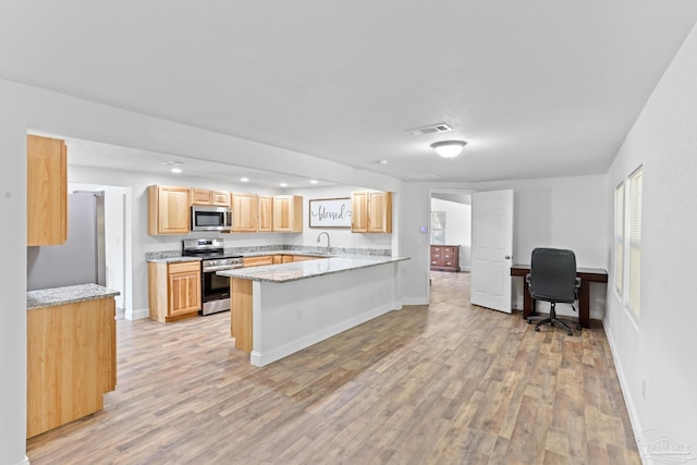 kitchen featuring light stone counters, visible vents, appliances with stainless steel finishes, light brown cabinets, and a peninsula