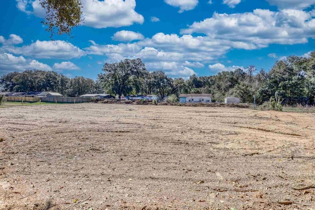 view of yard with fence and a rural view