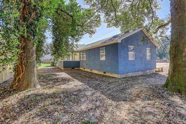 view of side of home featuring crawl space and stucco siding