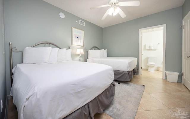 bedroom with light tile patterned floors, visible vents, a ceiling fan, and ensuite bathroom