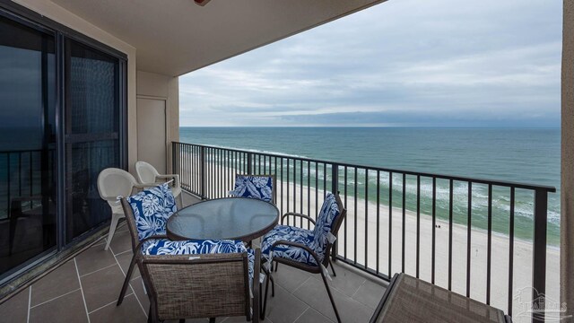 balcony featuring a view of the beach and a water view