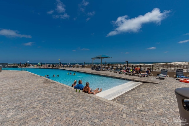 community pool featuring a patio and a water view