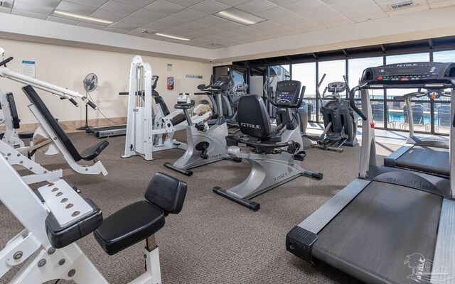 exercise room with a drop ceiling and visible vents