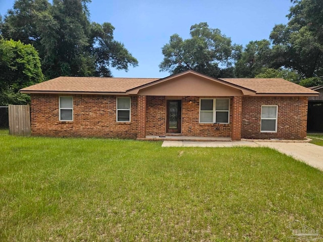 single story home featuring fence, brick siding, a front lawn, and a shingled roof