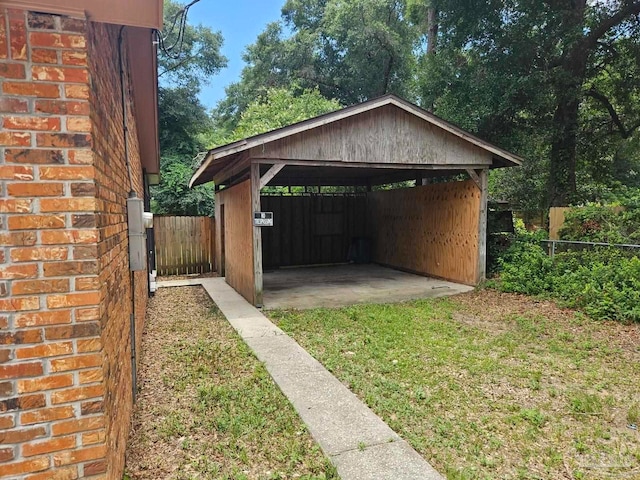 exterior space with a detached carport, driveway, and fence