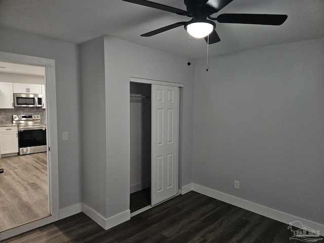 unfurnished bedroom with dark hardwood / wood-style floors, a closet, and ceiling fan