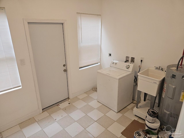 laundry area featuring washer / dryer, water heater, and light tile patterned floors