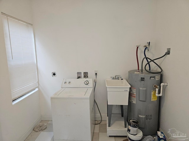 clothes washing area featuring washer / clothes dryer, light tile patterned floors, and water heater