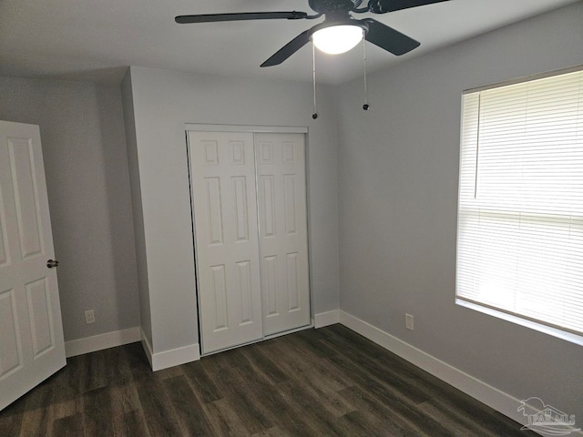 unfurnished bedroom featuring a closet, multiple windows, ceiling fan, and dark hardwood / wood-style floors