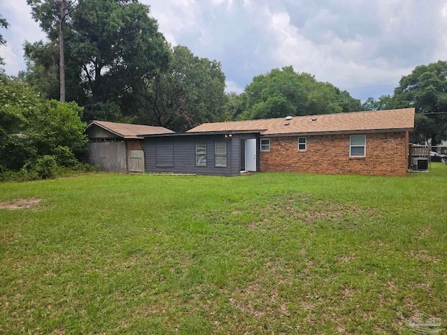 rear view of property with a lawn