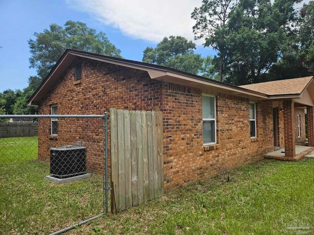 view of side of home featuring a lawn and central AC unit