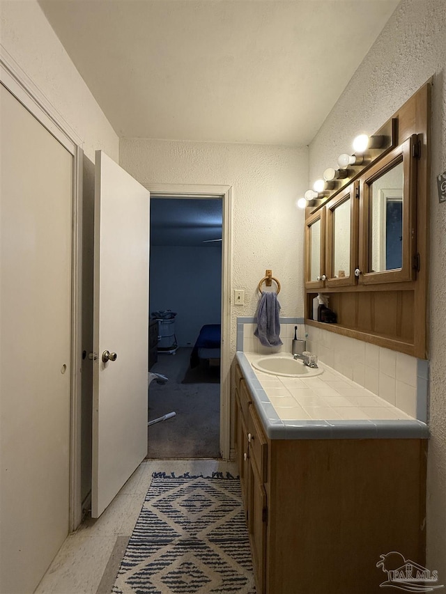 5325 Bob Sikes Blvd, Jay, FL 32565 - bathroom featuring vanity, a textured wall, and backsplash